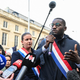 France Insoumise (LFI) party parliament member Carlos Martens Bilongo (C) delivers a speech during a demonstration organized by France Insoumise (LFI) to denounce racist remarks made by a far-right member of parliament directed at him during a National Assembly session one day prior, outside the National Assembly in Paris, on November 4, 2022. - A French parliament session was thrown into turmoil on November 3, 2022, after a far-right MP was accused of yelling “back to Africa” to Carlos Martens Bilongo of the leftist France Unbowed party (LFI), posing a question on migrant arrivals to the government.